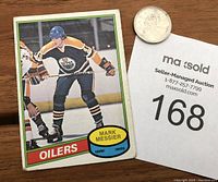 Front of the 1980-81 OPC Mark Messier rookie hockey card showing player in Oilers uniform with crease at top left and worn corners.