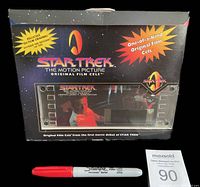 Front view of original film cel in its branded Star Trek motion picture box packaging, including scale reference marker (Sharpie) and auction card.