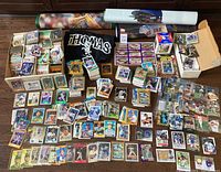 Spread of loose baseball cards in stacks and boxes, black Frank Thomas New with Tags t-shirt, three rolled player posters.