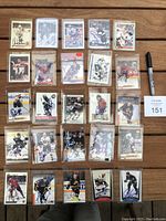 Full layout of 25 autographed hockey cards in plastic sleeves on wood table.