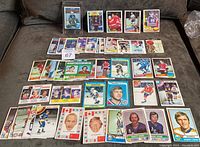 Overview photo of 48 hockey cards spread across a surface, showing a mix of cards from 1972/73 to 1988/89, mostly OPC.