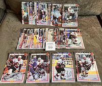 Overhead view showing two sets of Ottawa Senators hockey photo cards: a smaller set on top, a larger set below, with 4 cards in foreground signed in black Sharpie.