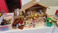 Overview of wooden dollhouse interior with assorted furniture and miniatures