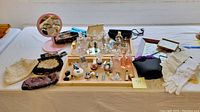 Overview of wooden trays holding 20+ perfume bottles, vials, purses, gloves, mirror