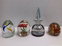 Four glass paperweights side by side on white background