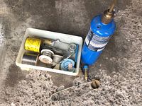 Full lot overhead view showing propane canister, blowtorch attachment, plumbing accessories and soldering supplies in white tray on concrete floor.