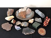 Overview of all 14 rock and mineral specimens on black cloth
