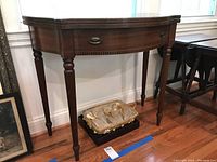 Full side view of the drop leaf table showing front drawer, leg detail, and shape.
