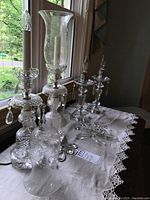 Set of 4 glass hurricane style lamps arranged on a table showing overall size and design.