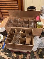 Box containing over 30 various Early American pattern glass goblets in clear and colored glass with protective compartment dividers