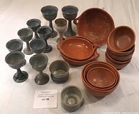 Group shot of all pottery pieces including goblets and bowls arranged on a flat surface.