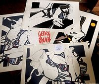 Four unframed prints laid flat on wood floor with Georg Rauch signature visible