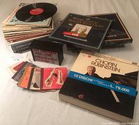 Overall lot view showing stacks of vinyl LPs, box sets and small-format CD discs