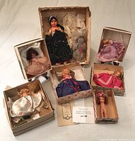 Full lot of 8 vintage storybook dolls in their original boxes, arranged on a surface showing variety of doll styles and box conditions.