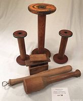 Photo showing all items: three wooden spools (one large, two smaller), two wooden mallet-like tools, and the small wooden box-like object.
