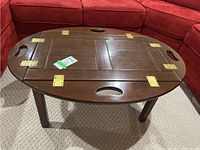 Top angled view of the oval Bombay coffee table showing the fold-up sides hinged with brass hinges and handle cut-outs on each side.