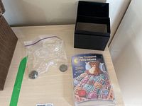 Original lot setup showing black foldable storage box and resealable plastic bag with loose coins.
