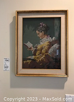 Framed textile print of a woman reading with a gold-colored frame