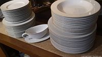 Stacks of dinner, luncheon, side plates, soup bowls, and gravy boat with underplate