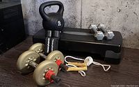 Wide shot showing all lot contents including the 5 kg kettlebell, various dumbbells, step bench, and skipping rope.
