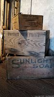 Three wooden crates stacked, largest with Sunlight Soap branding, medium with LCB Toronto and Portugal produce markings, small crate partially visible