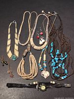 Full view of vintage costume necklaces, earrings, and watches, showing variety of bead styles and colors including turquoise, cream, brown, and red earrings.