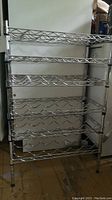Front view of the chrome metal wire wine rack with six adjustable shelves and wave pattern bottle holders.