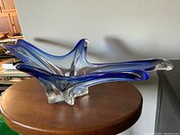 Front view of blue to clear stretch art glass sculpture showing shape and gradient color.