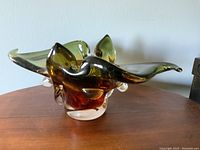Front-side view showing green to amber gradient and curled edges of the art glass bowl.