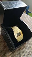 Birks gold-toned digital metal bracelet watch displayed inside a black leather-like presentation box.