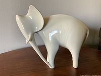 Front view of white porcelain elephant figurine showing trunk and ear shape