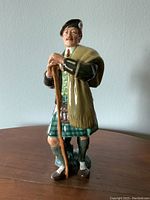 Front view of the Royal Doulton figurine The Laird showing facial features, kilt, and walking stick.
