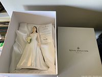 View of the figurine in its original Royal Doulton box with satin lining and certificate.