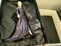 Figurine of Diana, Princess of Wales, inside original black satin-lined box, showing detailed side profile in purple gown.