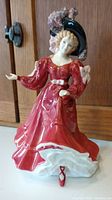 Full view of Royal Doulton Patricia figurine showing red dress and black hat with pink feathers