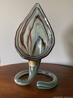 Front view of the mid century art glass vase showing the swirl base and the jack-in-the-pulpit style upper section with brown, green, and white swirls.