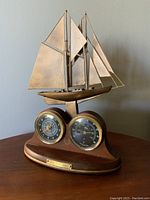 Full view of the limited edition nautical decorative piece showing the wooden base with two dials and the ship model on top