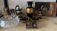 Front view of entire lot showing all items including Greek-style ceramic vases, glass bowl, ashtrays, and decorative box with gold trim.