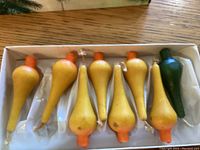 Photo of 8 vintage Christmas tree candles in original packaging showing 7 yellow candles and 1 green candle arranged in a molded tray.