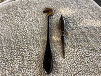 Photo of horse head shoe horn and wooden letter opener placed on a carpet.