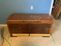 Front view of large Lane veneer cedar chest showing water stains on top surface, veneer loss on bottom front, and wood grain finish