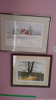 Two framed numbered art prints by Alan Kingsland hanging on a pink wall, showing "Old Red" (top) and "Broken Fence" (bottom).