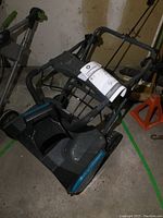 Full view of the Yardworks snow thrower showing folding handle, body and wheels.