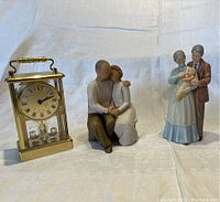 Photo showing all three items: brass Birks carriage clock, seated couple figurine, elderly couple figurine