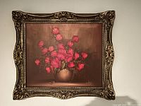 Full view of framed oil painting showing red roses in a vase with detailed ornate gold frame.
