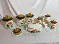 Wide view of all 13 ceramic pieces on white backdrop