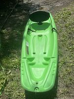 Overhead view of lime green Pelican Solo kids kayak showing the molded seat area, footrests, and carry handle.