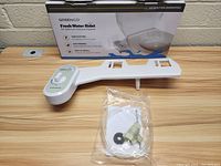 Front angle view of Greenco Fresh Water Bidet attachment, control dial, mounting hardware in plastic bag, and product box.