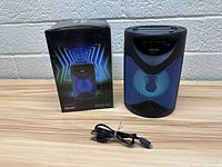 Photo showing Max Power Boom-M3 Bluetooth speaker, power cable, and original box with graphic design and model name.