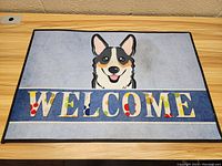Top-down photo clearly showing the cartoon dog and the full 'WELCOME' text with colorful letters including a red paw print detail